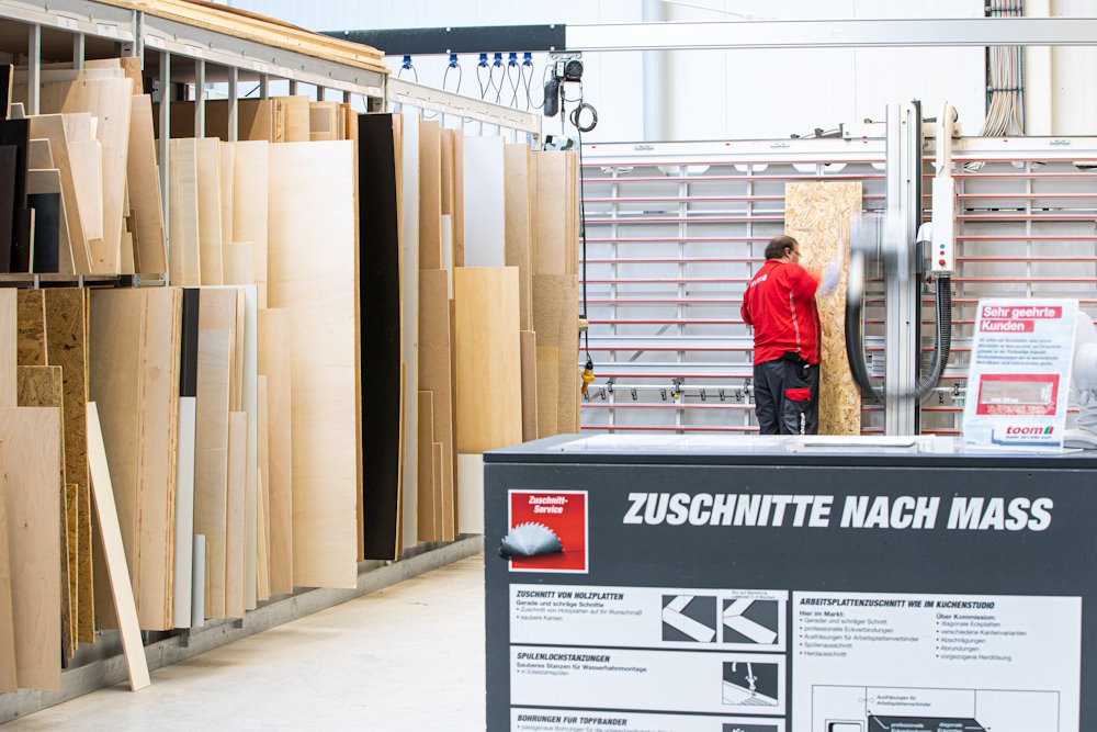 Person sägt Holzplatte mit einer Säge zu